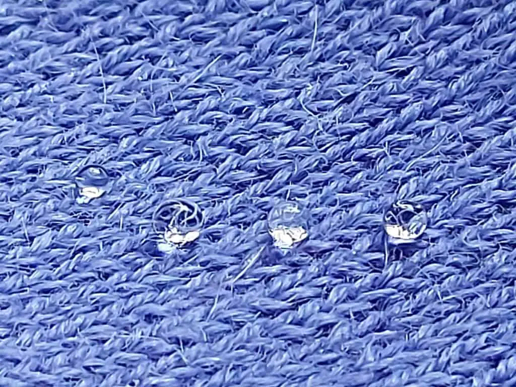 Alpaca Woolen Garment Knitted Texture with Three Water Drops on top of the fabric
