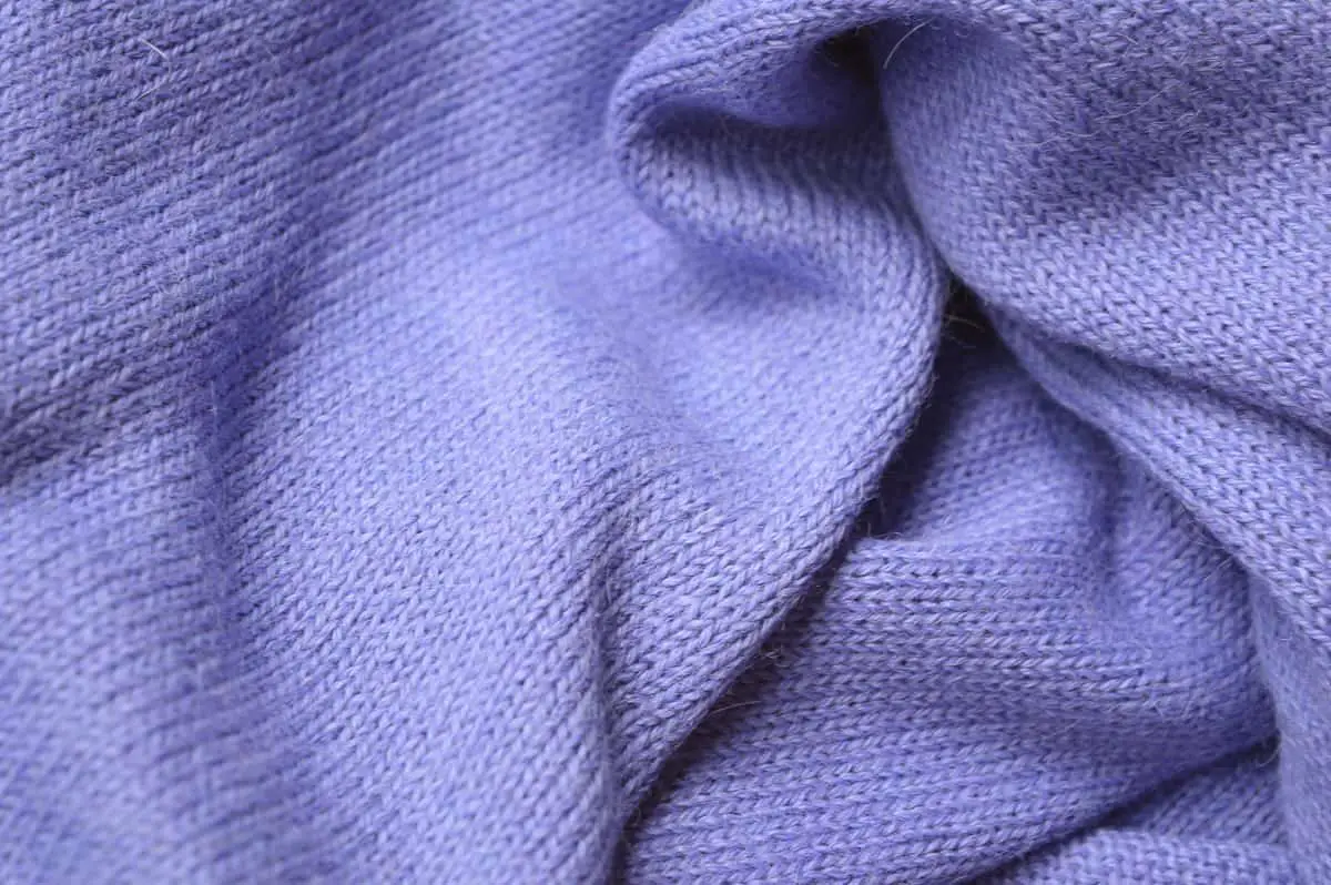 100% alpaca woolen scarf. Knitted scarf with medium fine sitch. Crocheted border and vegan "leather" label. Bright lavender color, close up.