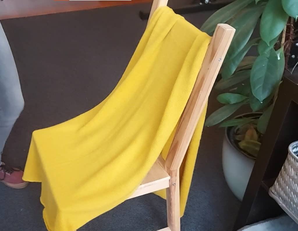 An alpaca woolen scarf is hanging over a chair. It is the easy way to remove wrinkles from an alpaca woolen arment. Gravity will straighten out your garment in a heartbeat!
