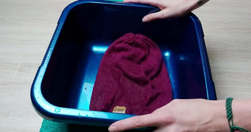 Image of a recently washed alpaca woolen garment. It is inside the tub to make sure that the garment is supported and the weight can't pull the garment out of shape.