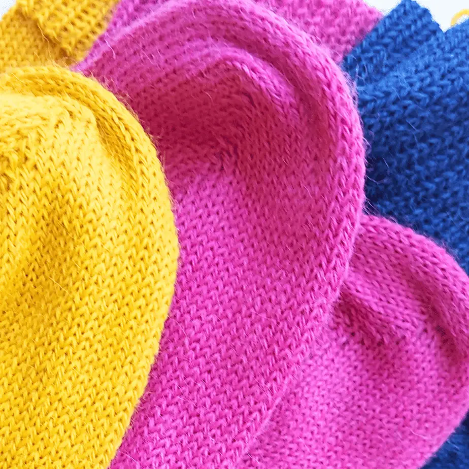 Three pairs of knitted socks, made with 100% alpaca wool. Playfully put together, in the colors: yellow, fuchsia and blue.
